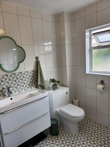 Updated bathroom design with a sleek white vanity unit, geometric feature tiles and fresh modern decor in a Bedworth home.