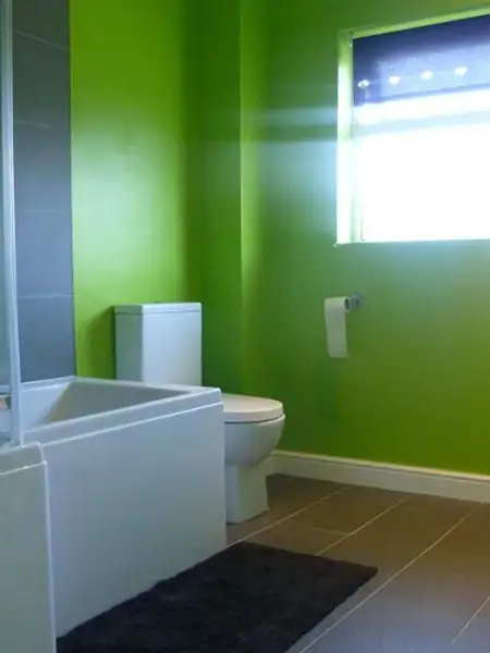 The bathroom before renovation showing bright green walls and older fixtures in a Bedworth home, prior to modern refurbishment.