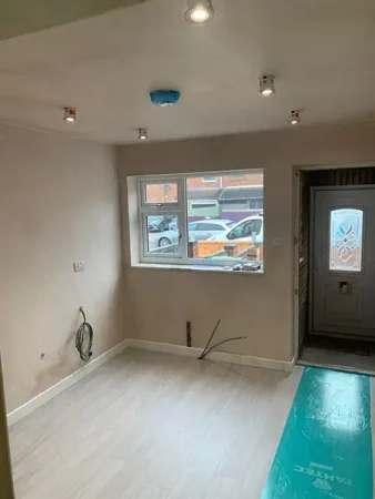 Nearly completed garage conversion living space in Coventry with plastered walls, recessed lighting and new flooring.